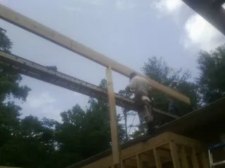 Carpenter setting a ridge beam over a new addition frame — Ice Dam Removal by Roofing Brothers in Drumore