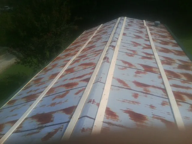 Rusted metal roof panels with new wood purlins before replacement — Storm Damage Roof Repair in Drumore by Roofing Brothers