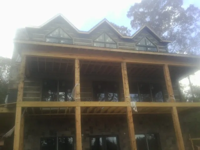 Dormers and porch framing on a large log home under construction — Roof Coating work by our crew in Drumore