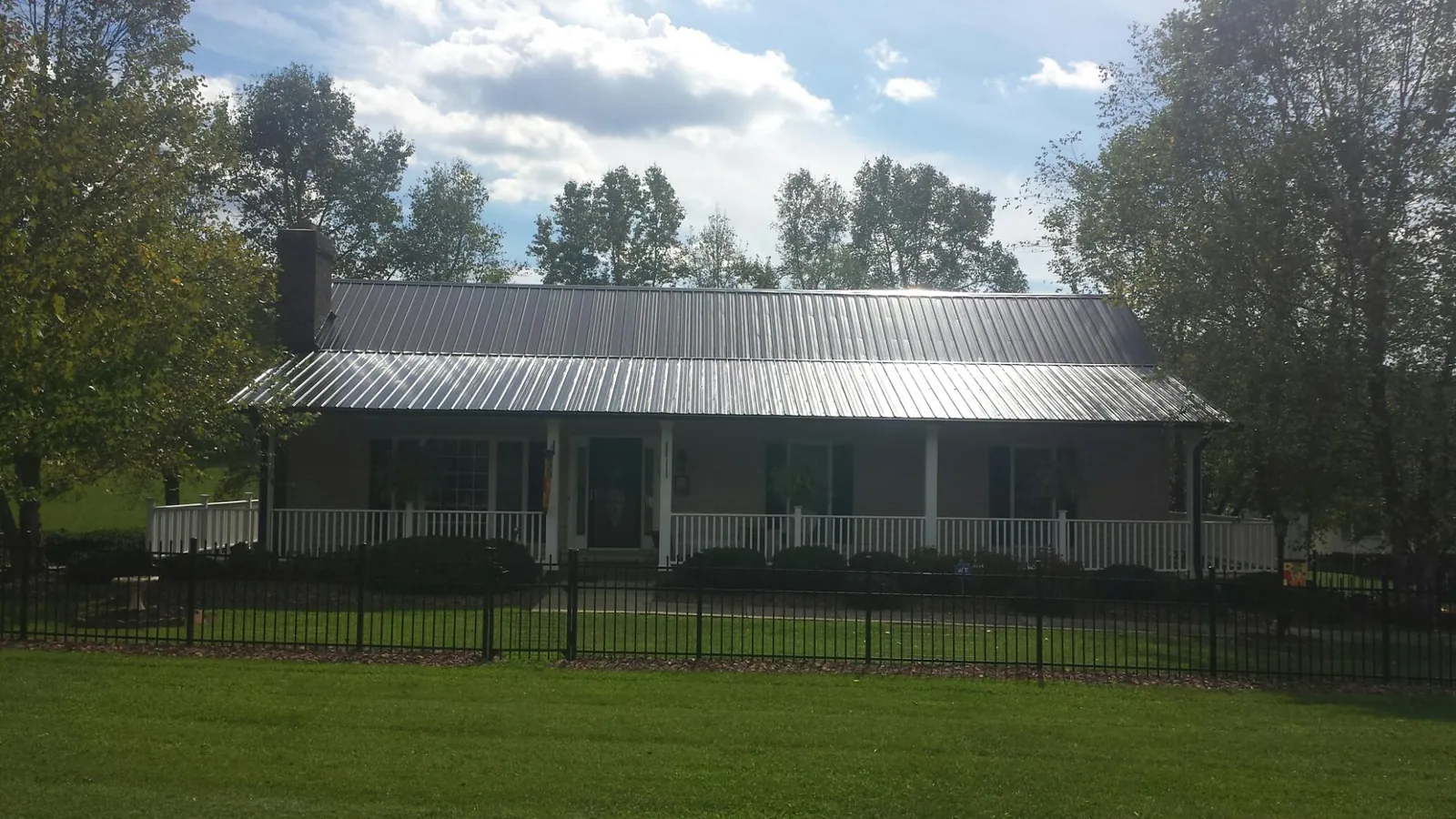 Gray metal roof on a brick ranch with a full width front porch — Gutter Guard Installation work by our crew in Drumore