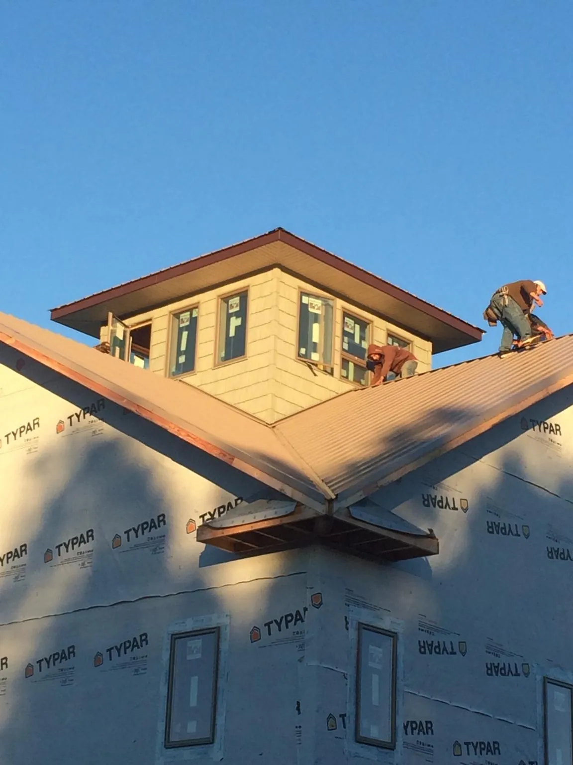 Roofers working around a rooftop cupola on a new metal roof at sunset — Roof Waterproofing in Drumore by Roofing Brothers